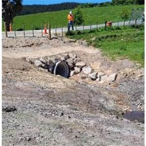A person standing next to a hole in the ground

Description automatically generated with low confidence