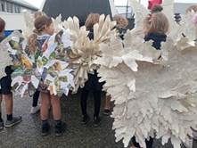 A group of children wearing paper wings

Description automatically generated