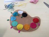 A felt art piece with colorful circles and needles

Description automatically generated