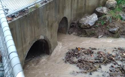 A water flowing through a concrete wall

Description automatically generated