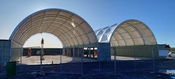 A white structure with a metal roof

Description automatically generated with medium confidence