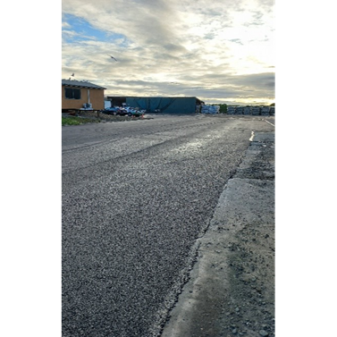 A road with a building in the background

Description automatically generated