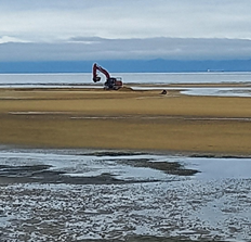 A construction vehicle on a beach

Description automatically generated