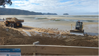 A construction site with bulldozers on the beach

Description automatically generated