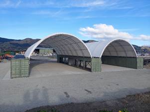 A large white structure with a curved roof

Description automatically generated