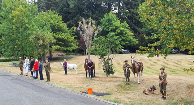 A group of people standing next to horses

Description automatically generated