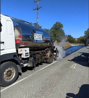 A truck with a tank on the side of the road

Description automatically generated