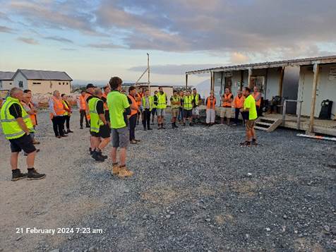 A group of people in orange vests

Description automatically generated