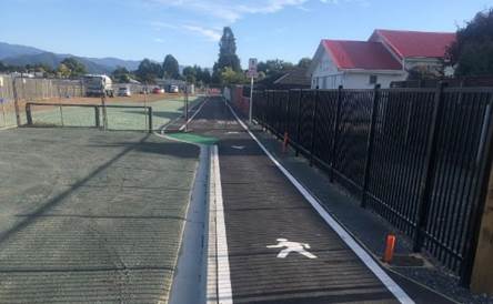 A black fence next to a road

Description automatically generated