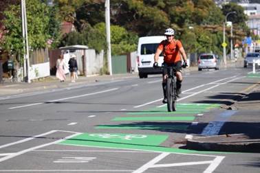 A person riding a bike on a street

Description automatically generated