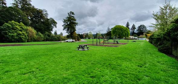 A park with picnic tables and playground equipment

Description automatically generated