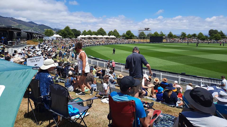 A group of people sitting in chairs at a sports field

Description automatically generated