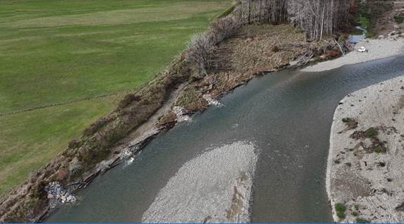 A river flowing through a grassy area

Description automatically generated