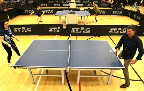 A group of people playing ping pong

Description automatically generated