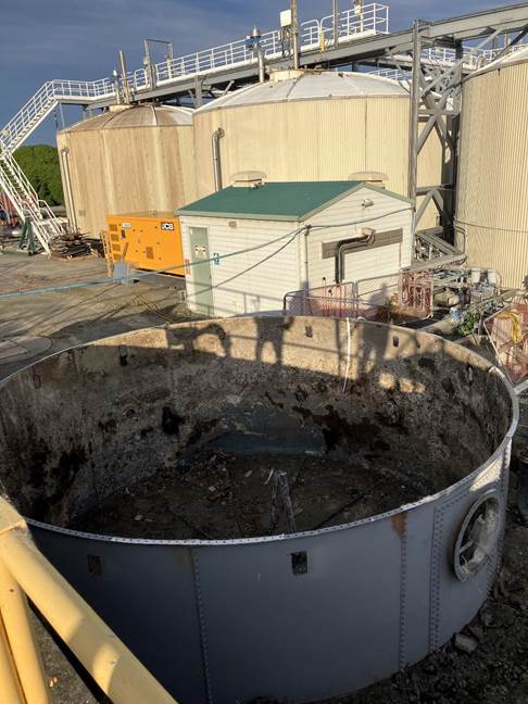 A large metal container with a yellow railing

AI-generated content may be incorrect.