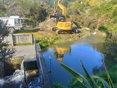 A construction site with a river and a yellow excavator

AI-generated content may be incorrect.