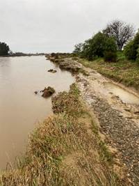 A dirt road with grass and water

AI-generated content may be incorrect.